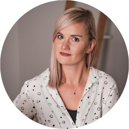 Nie wiem, kim jest ta osoba, ale to kobieta o jasnych włosach w białej koszuli w kropki, patrząca w stronę aparatu.